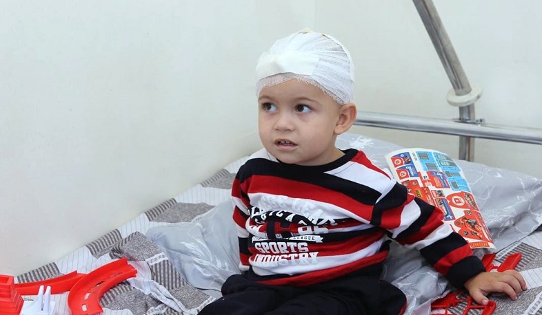 Injured by the heavy bombardment, 2-year-old Artsvik smiles again