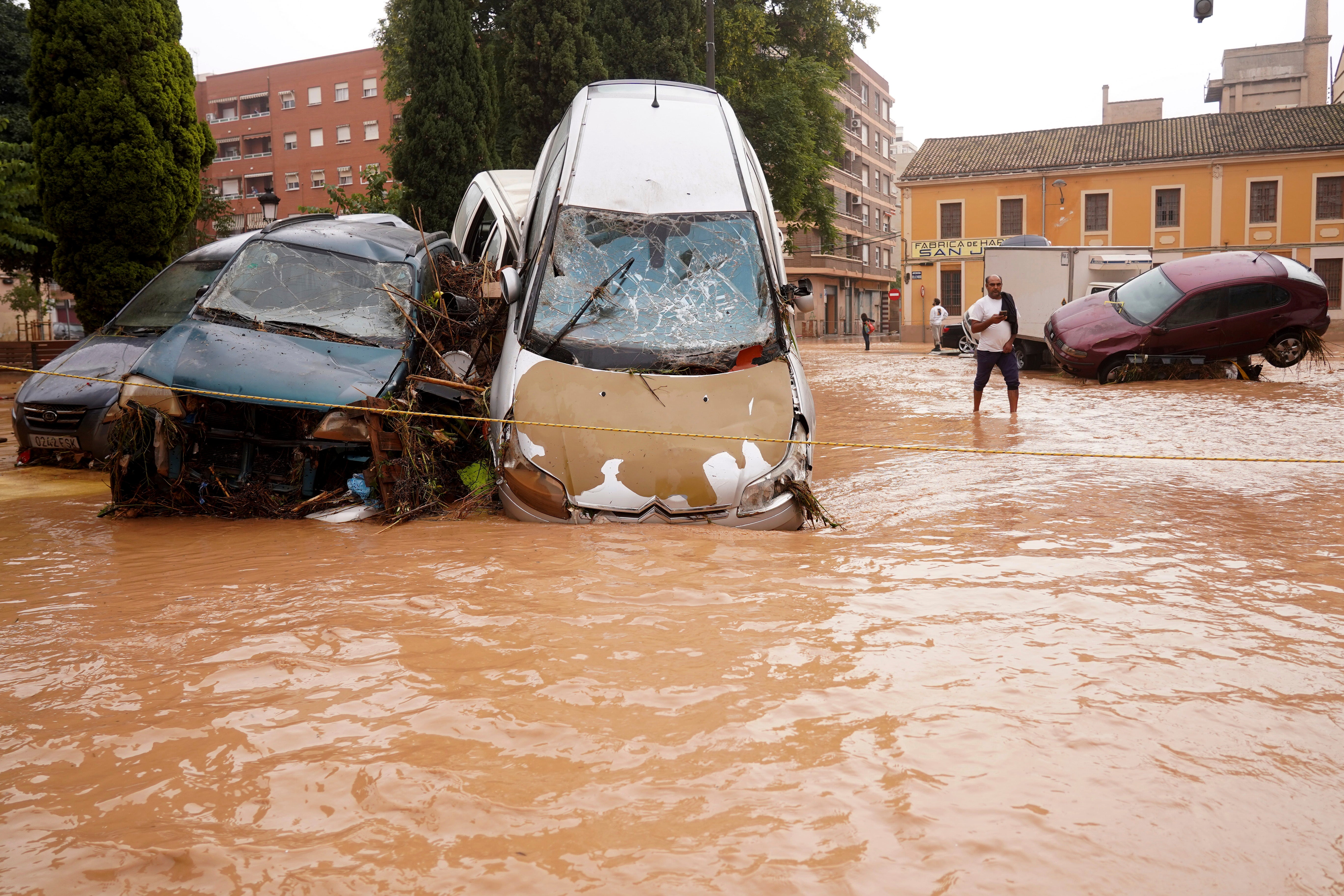 Cars drive through flooded roads in Valencia