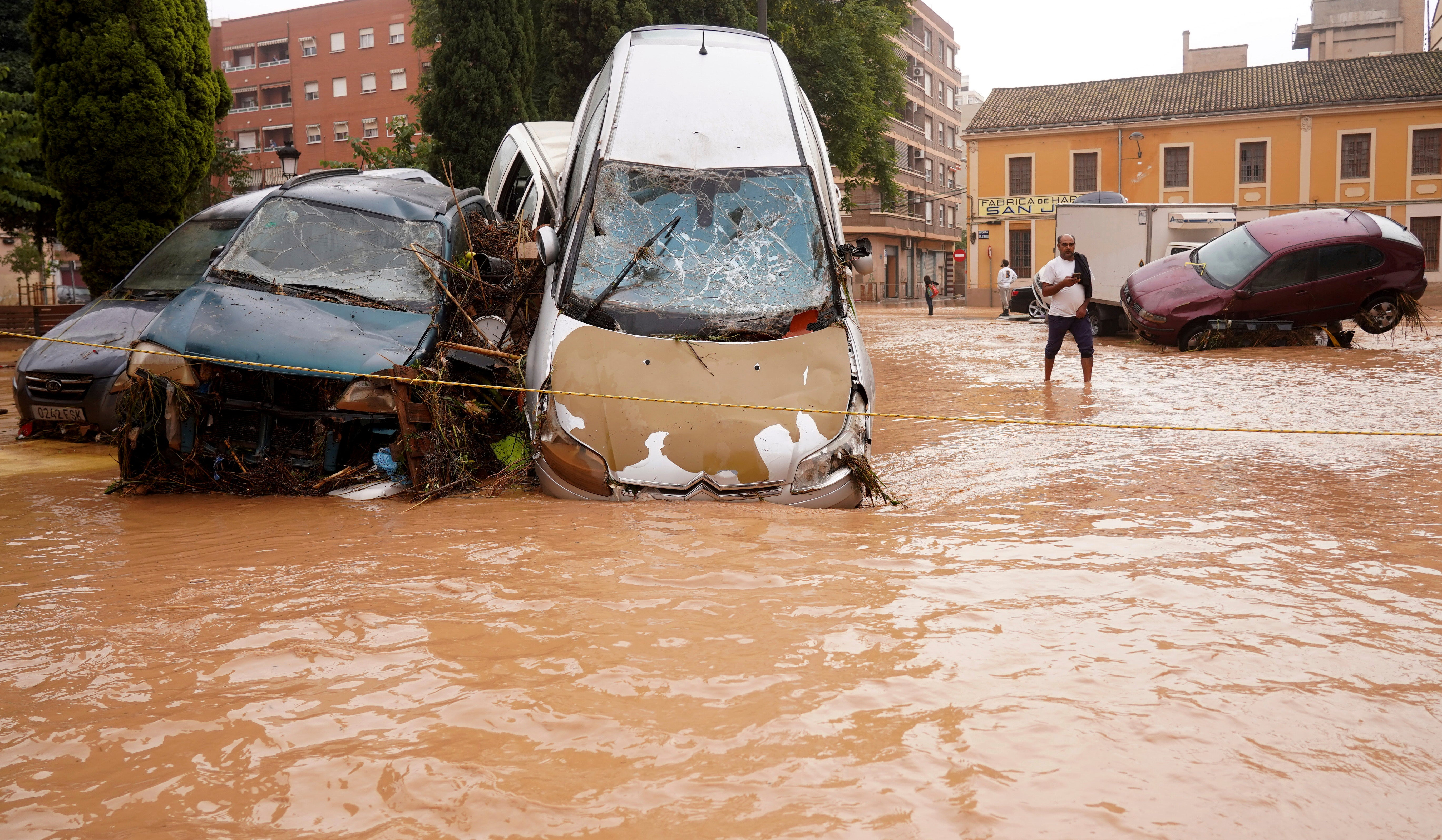 Cars drive through flooded roads in Valencia